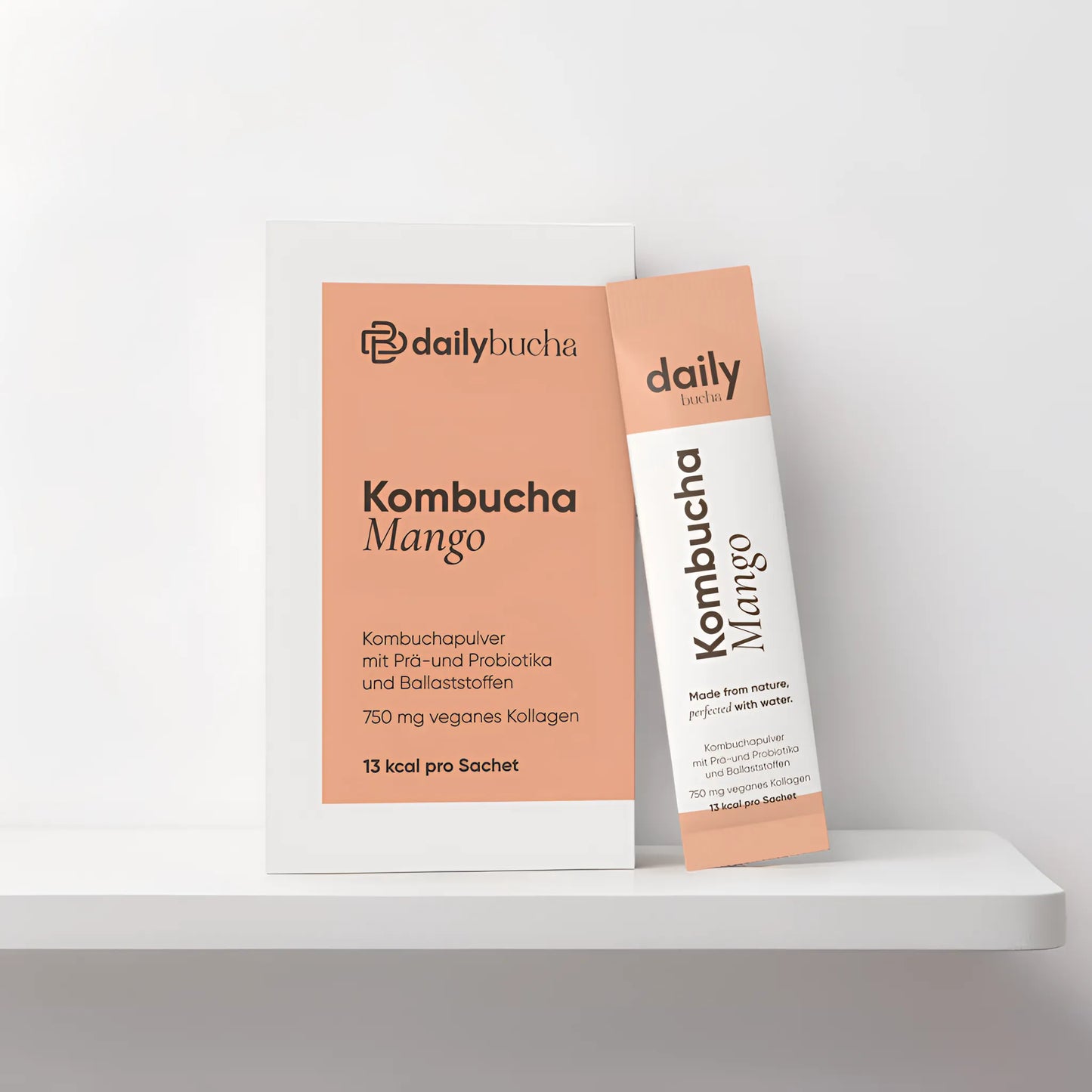 Daily Bucha Mango-Kombucha mit veganem Kollagen und Ballaststoffen, ohne Zuckerzusatz – Verpackung Vorderseite mit passendem Sachet