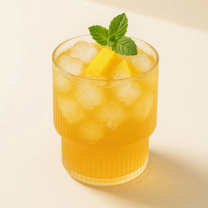 Daily Bucha Taste Set - Mango-Kombucha im Glas mit Eiswürfeln und Minze serviert