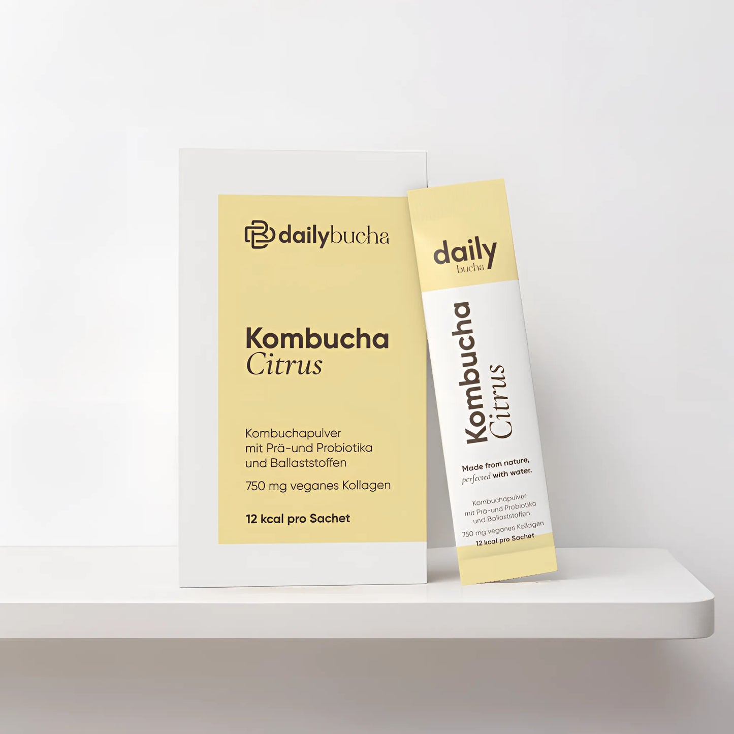 Daily Bucha Zitronen-Kombucha mit veganem Kollagen und Ballaststoffen, ohne Zuckerzusatz – Verpackung Vorderseite mit passendem Sachet
